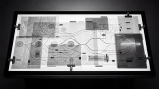 Wide horizontal forensic light table showing governed data paths and source traceability in black and white